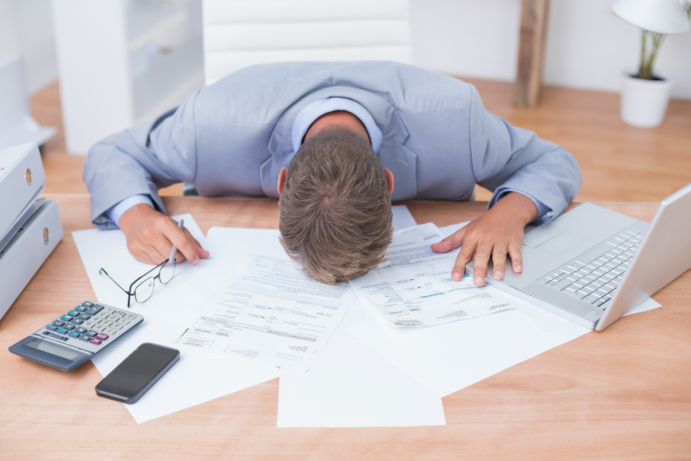 Businessman being depressed by accounting in his office Businessman being depressed by accounting in his office
